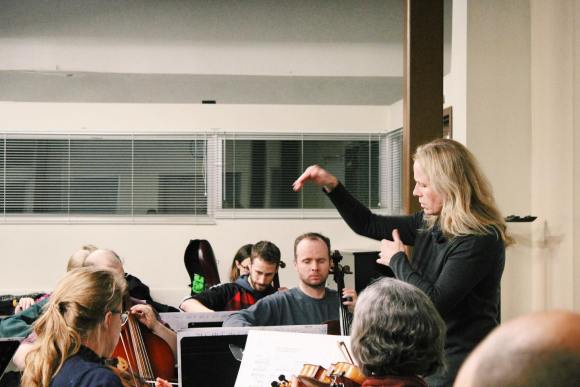 MCO conductor, Andrea Bell, conducting at rehearsal. Violins and cellos are pictured.